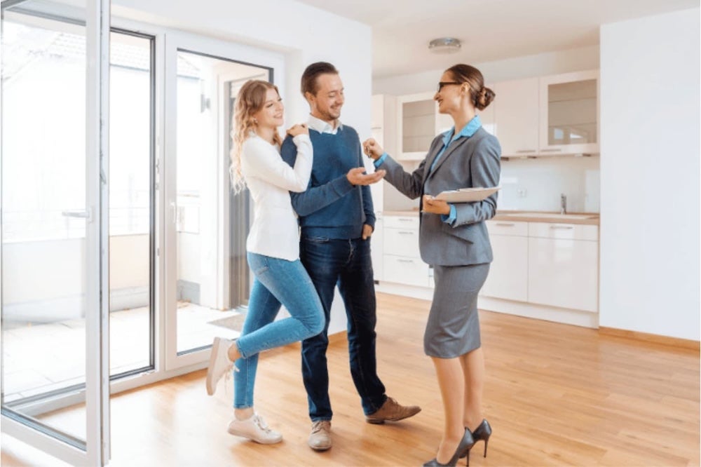 A couple being shown round an empty house