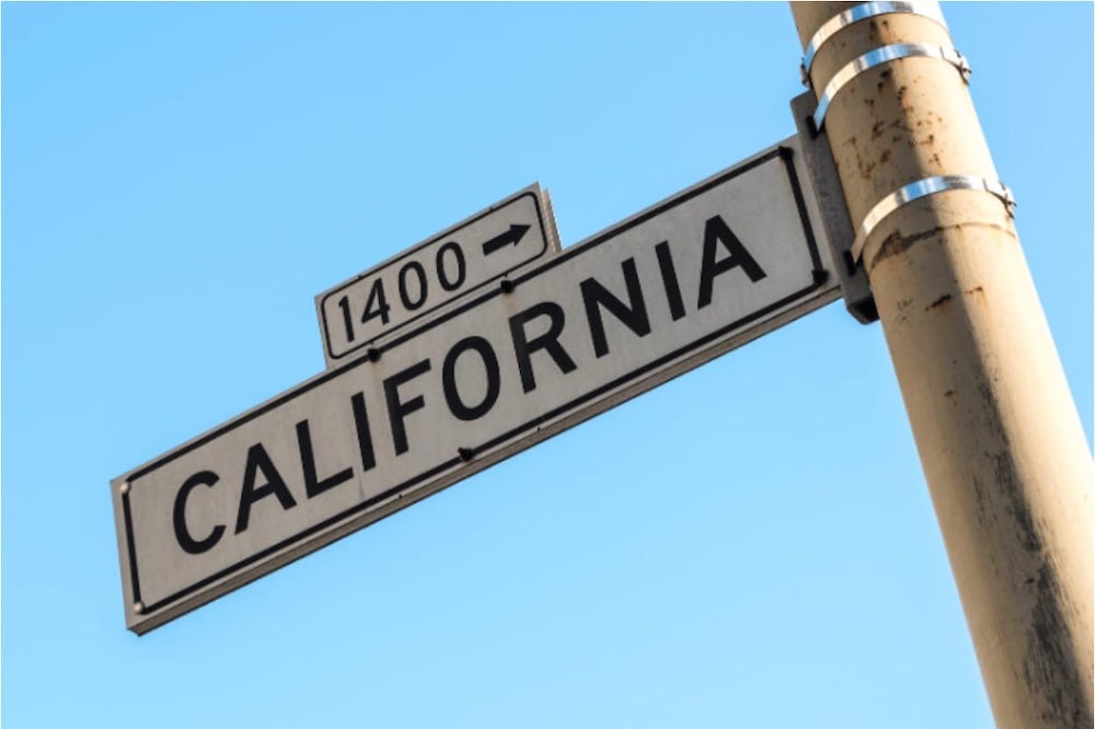 A street sign to California in front of a blue sky