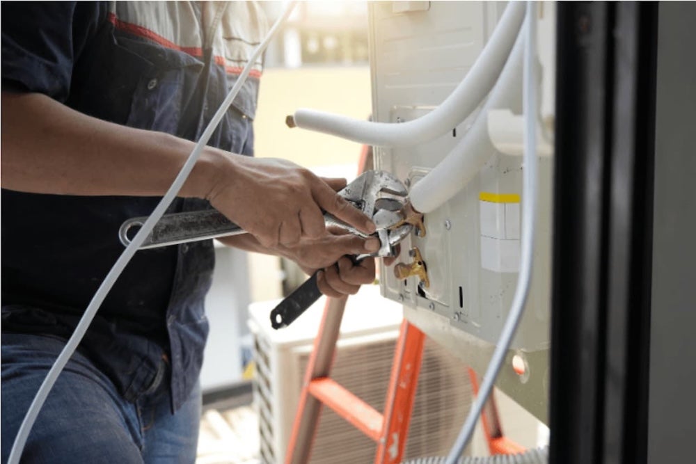 A plumber working on pipes in a house