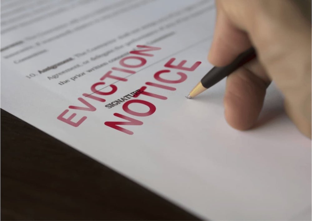 Someone going over an eviction notice with a pen