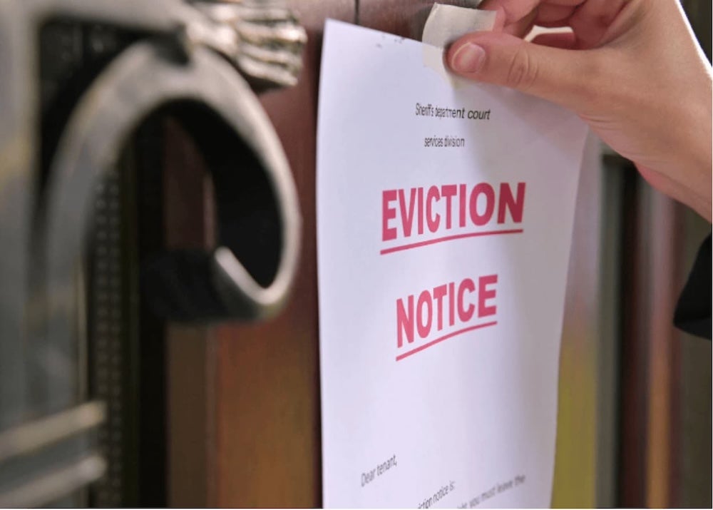 An eviction notice held up to a door