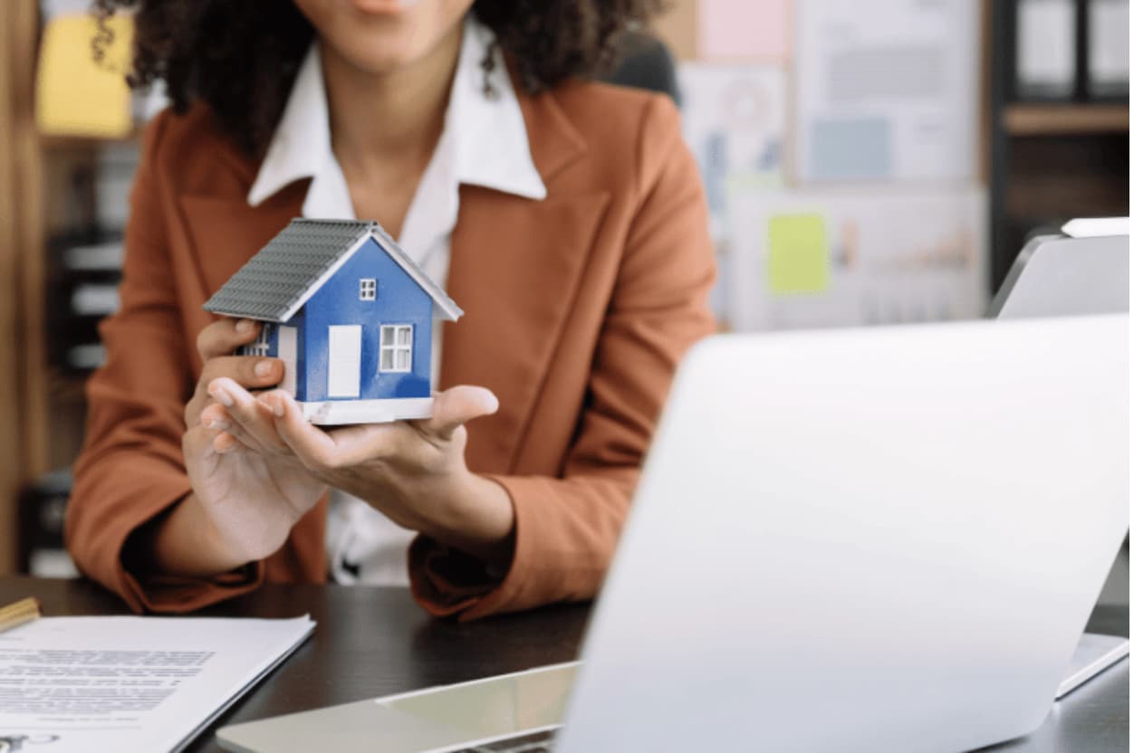 Someone holding a small model house