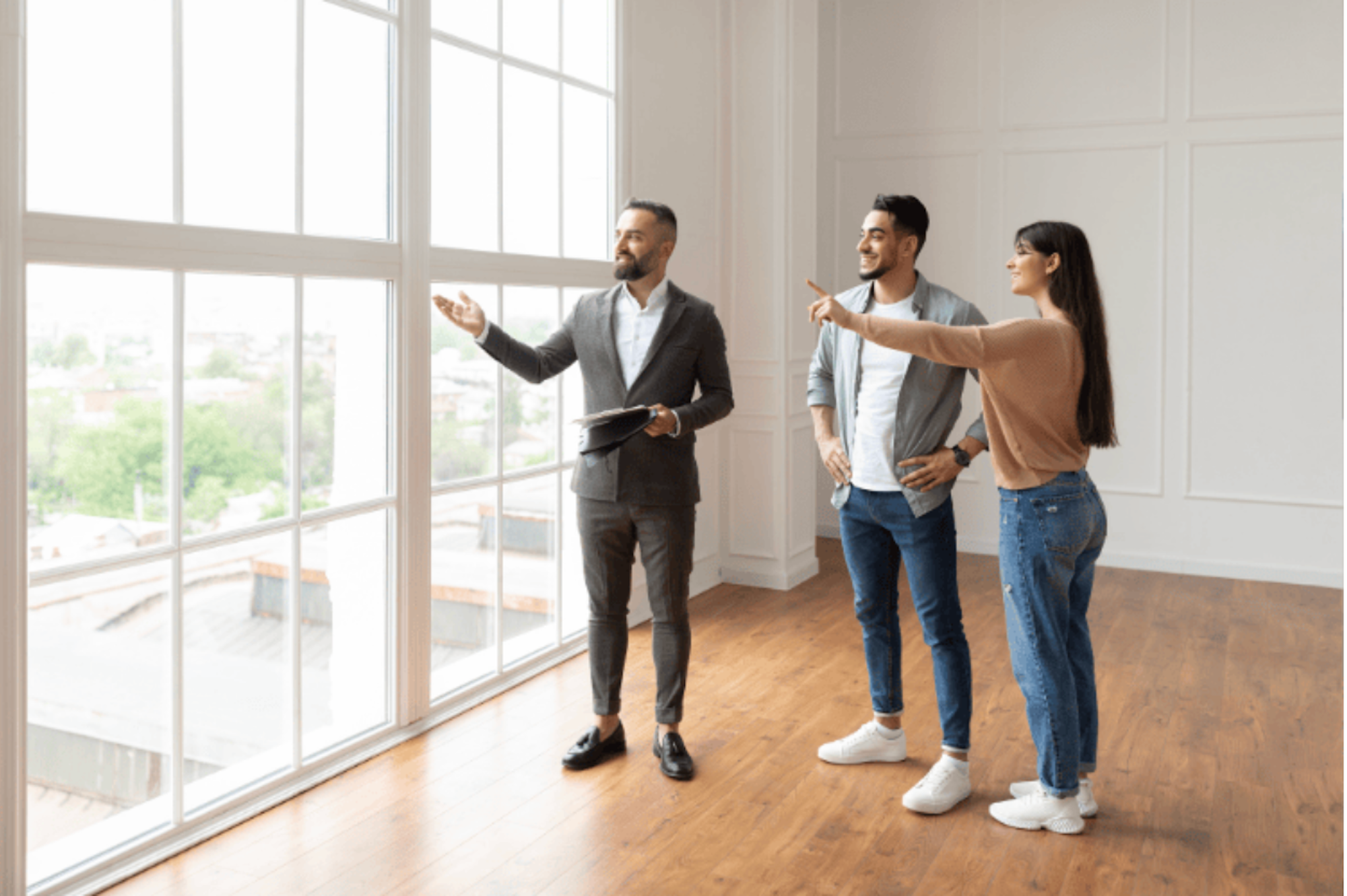An agent showing a couple round a house looking out a large window