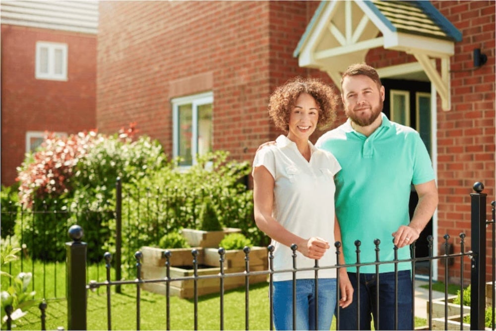 An image of a couple standing outside a house
