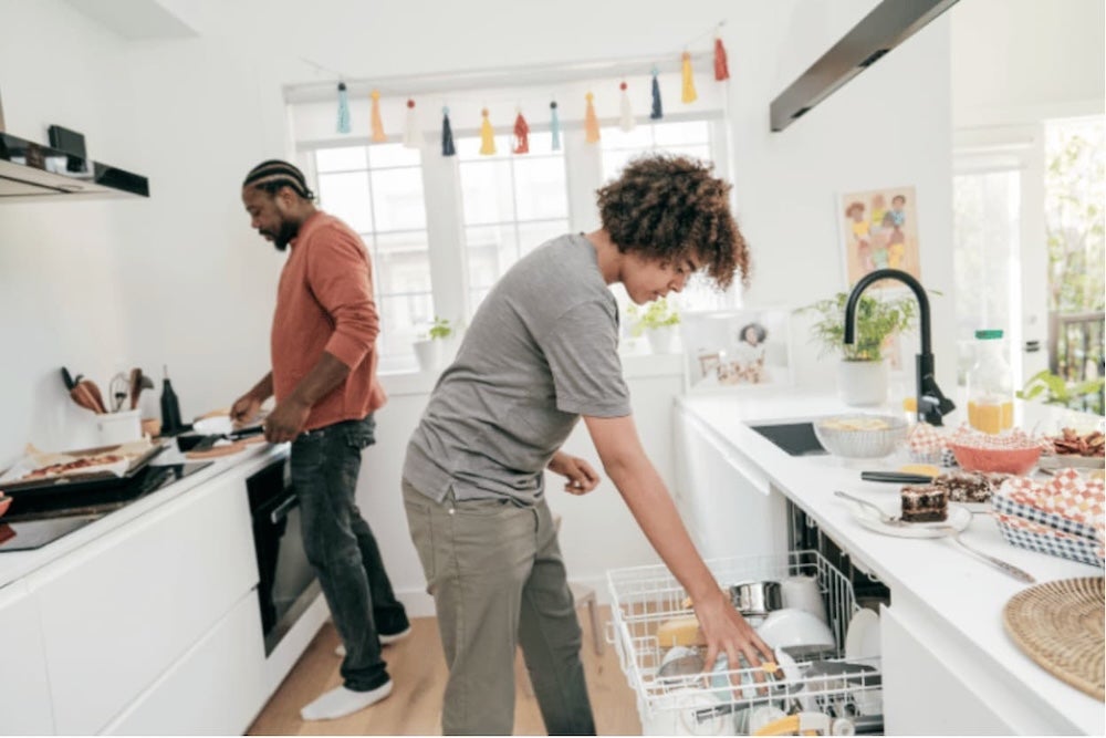 Two roommates in the kitchen cooking and cleaning