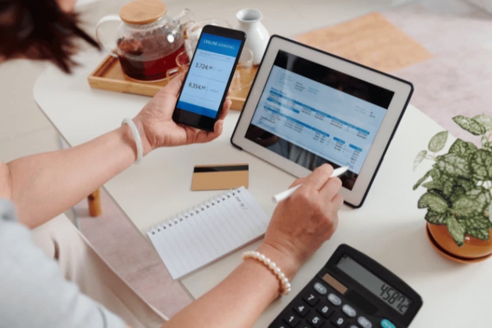 Somebody calculating finances on a tablet and phone