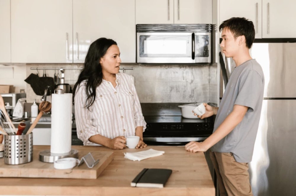 Two roommates conversing over coffee