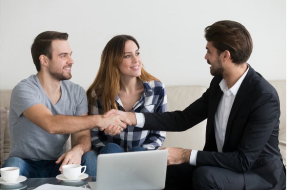 An agent shaking hands with a couple