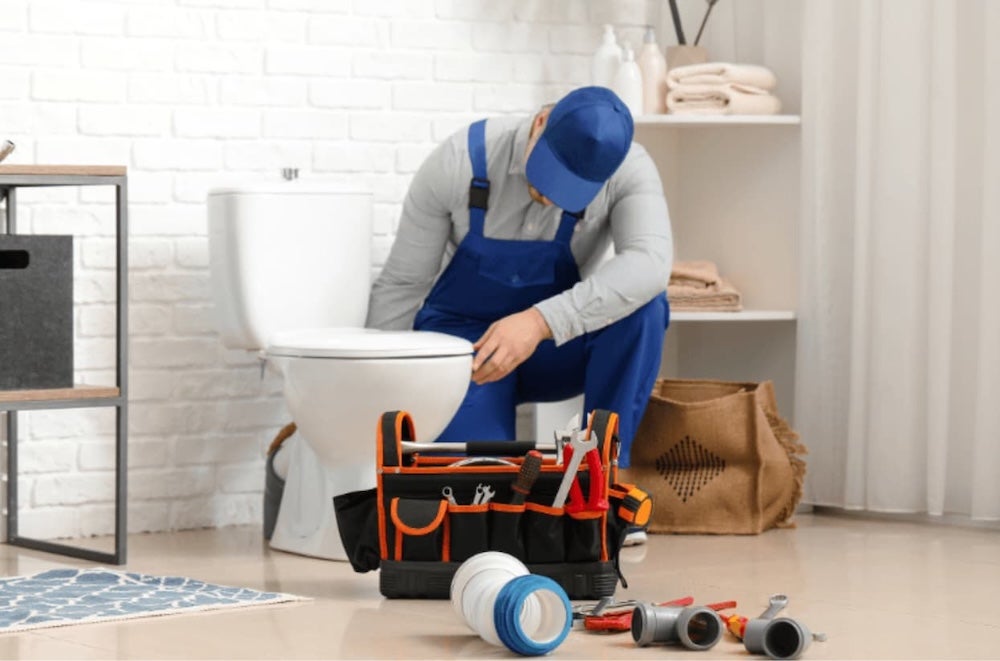A plumber fixing a toilet