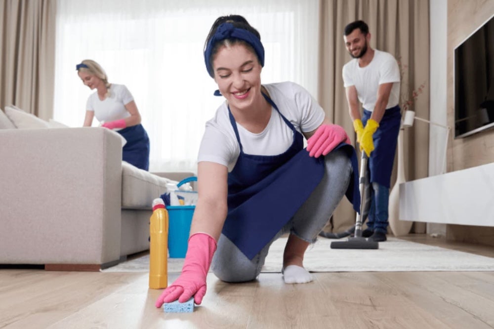 Three people cleaning a house