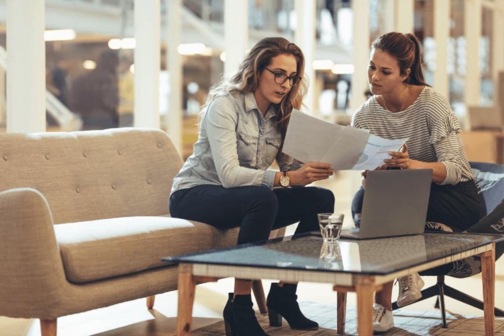 Two women conversing over a document