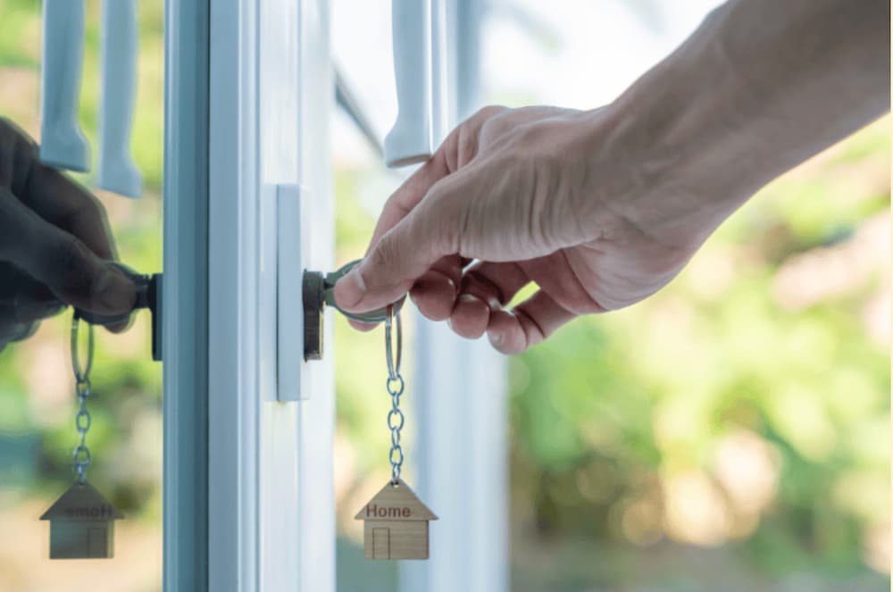 A hand putting a key into a glass door