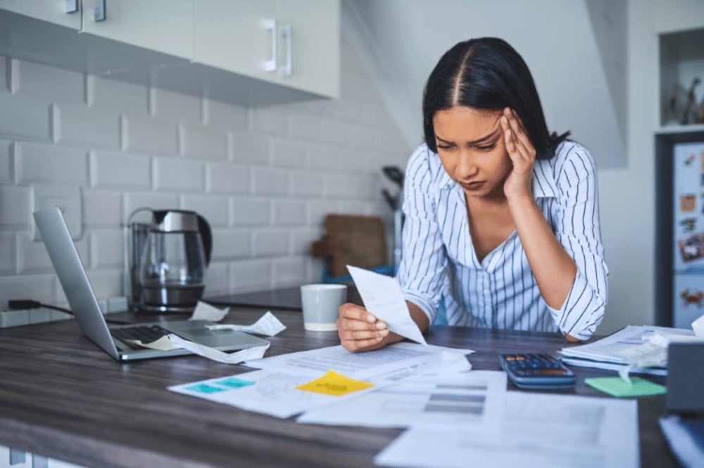 An image of someone looking at documents at a counter with laptop and calculator