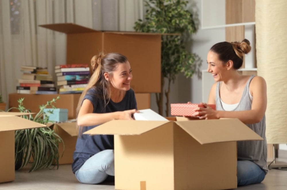 Two roommates unpacking a box