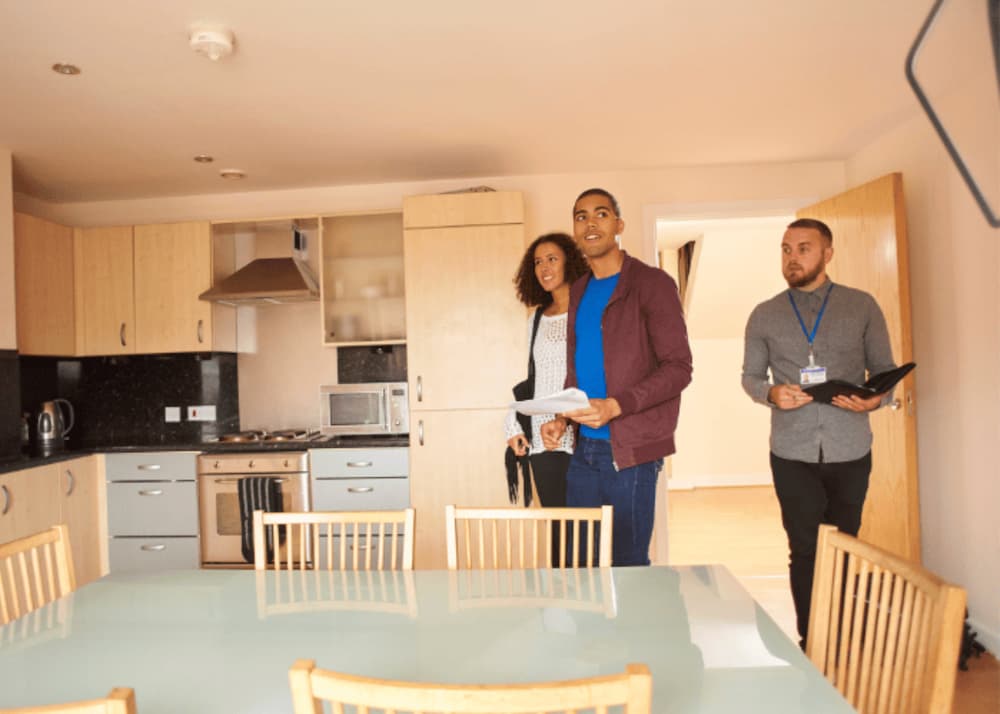An image of a couple being shown round a home