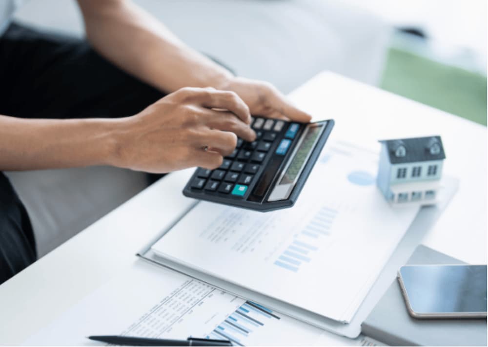 An image of someone holding a calculator, calculating rent