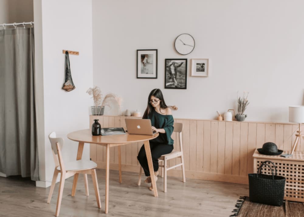 An image a woman working at a table in her appartment