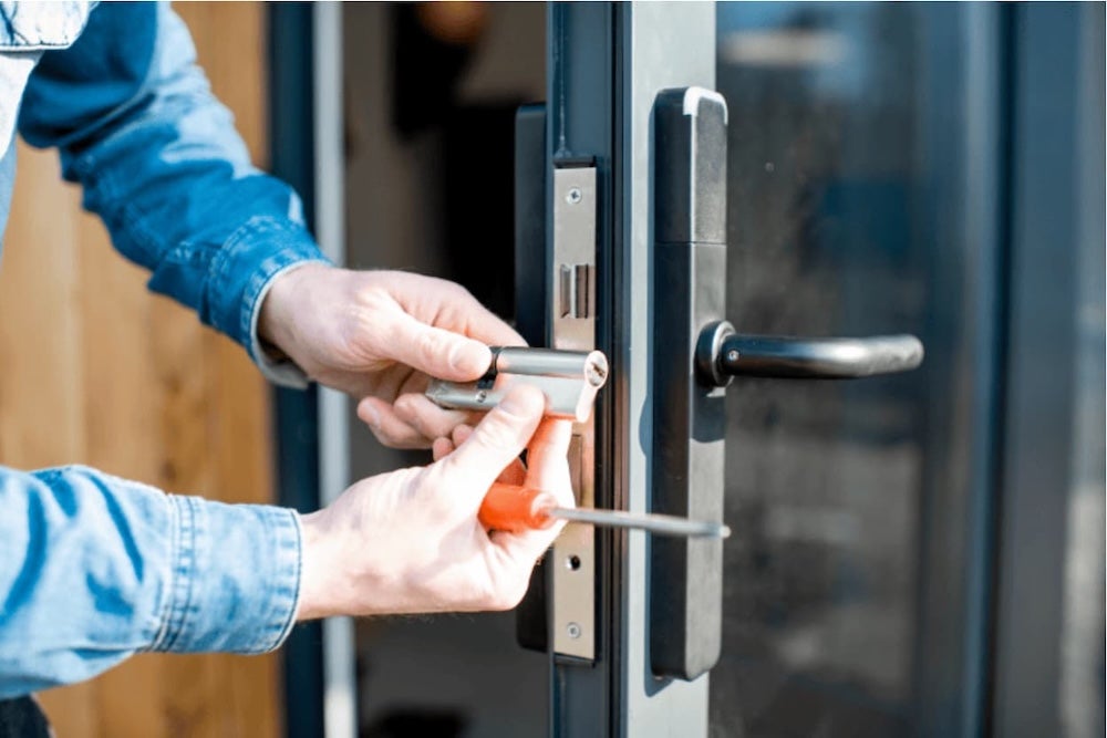 A locksmith installing a new door lock