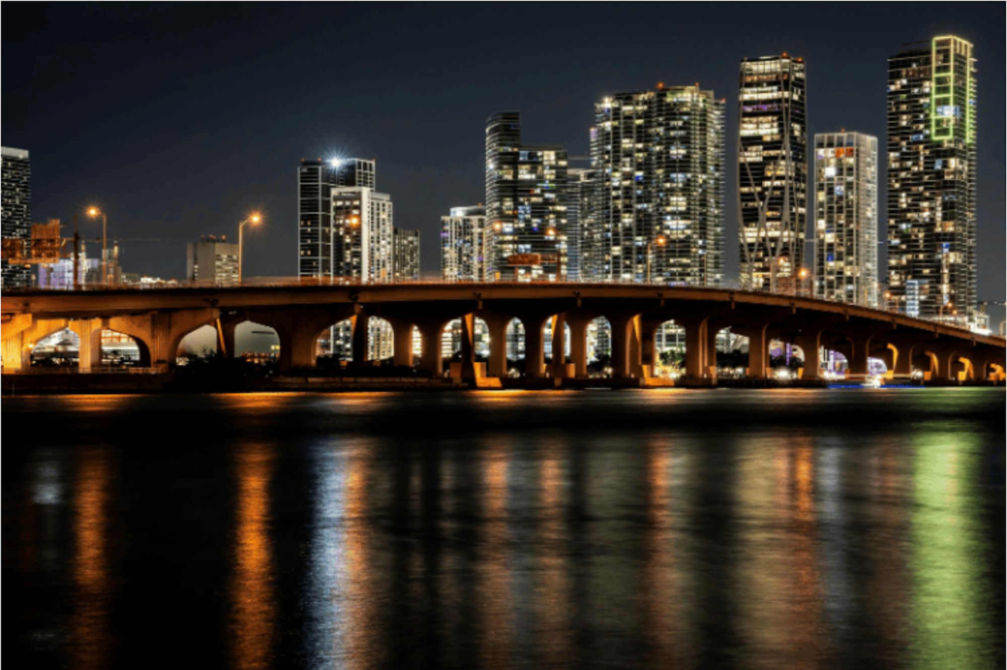 A view of a Miami bridge and street at night