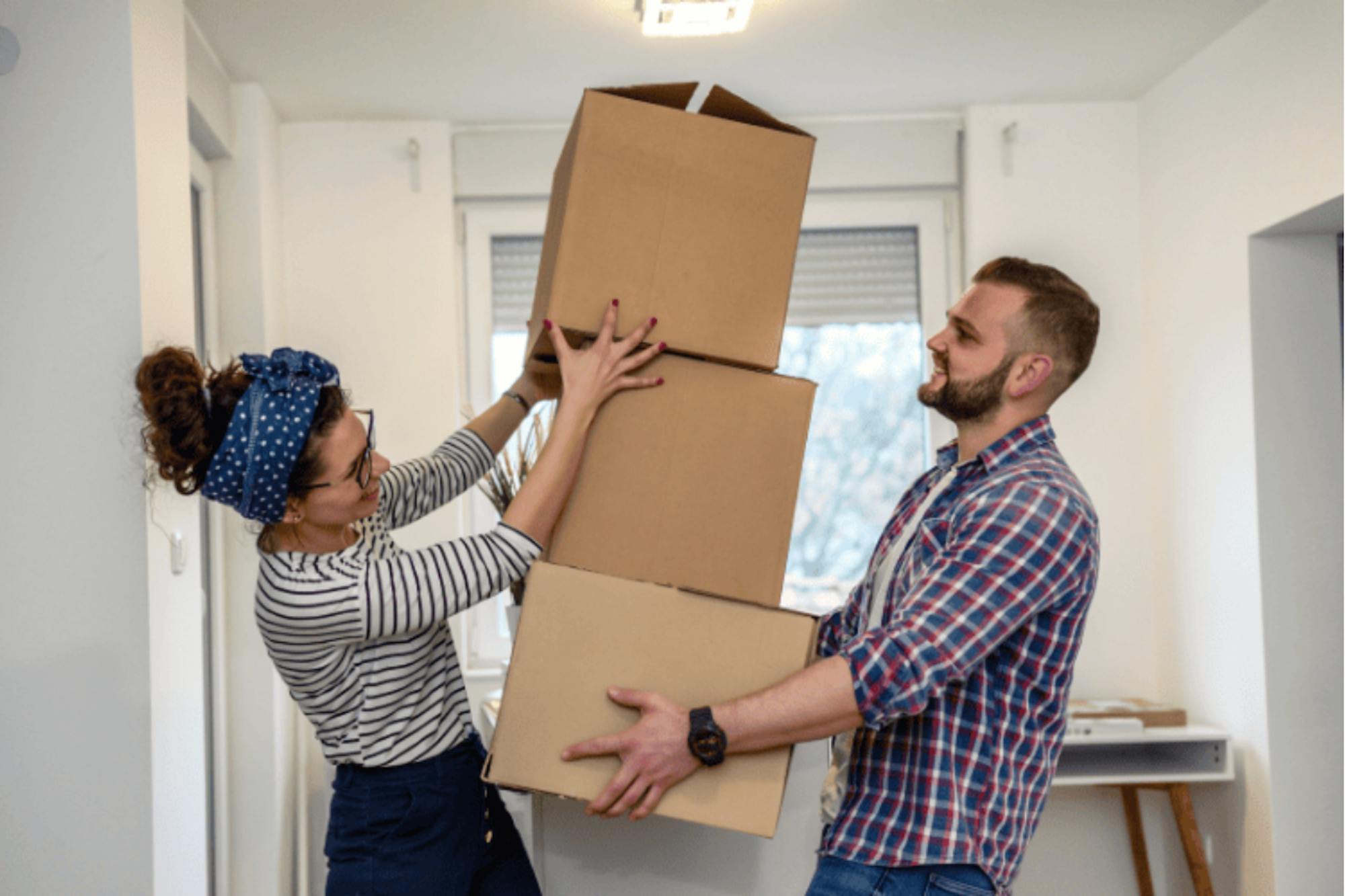 Someone carrying boxes and another person stacking them up