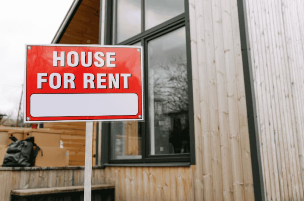 An image of a house for rent sign infront of a house