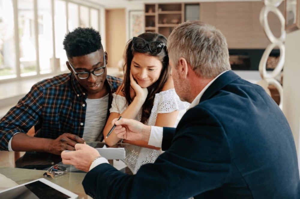 A couple getting ready to sign a documnet at a desk