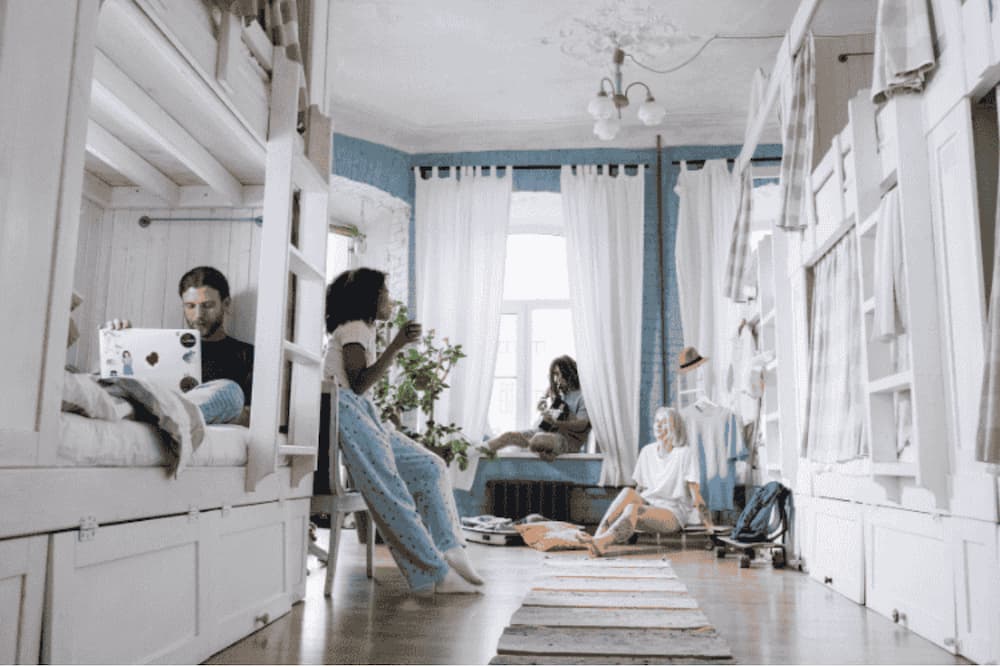 An image of 4 roommates relaxing in their room