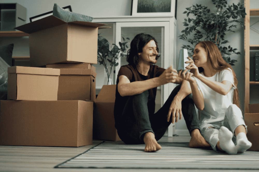 An image of a couple unpacking moving boxes