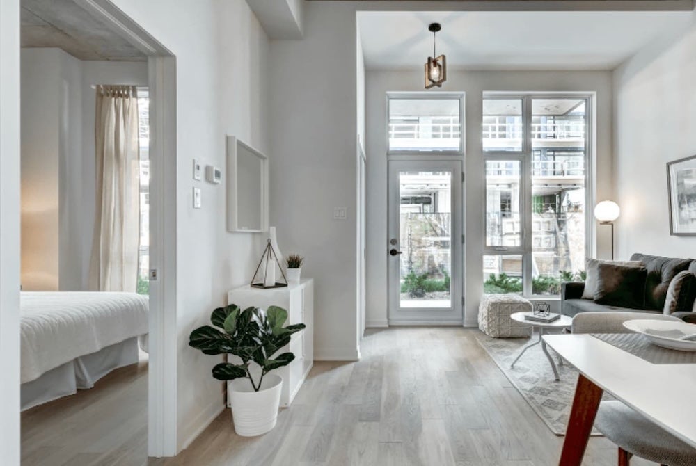 A view of a tidy living room leading to a bedroom