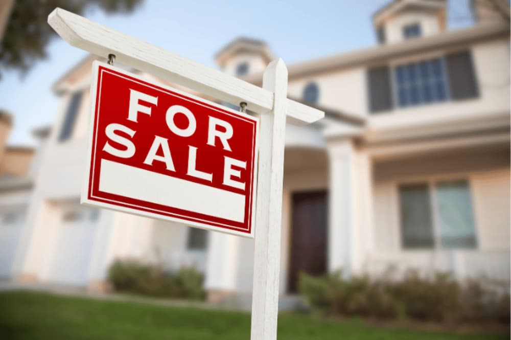 An image of a for sale sign infront of a house