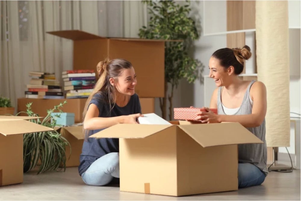 An image of two people unpacking boxes in a house