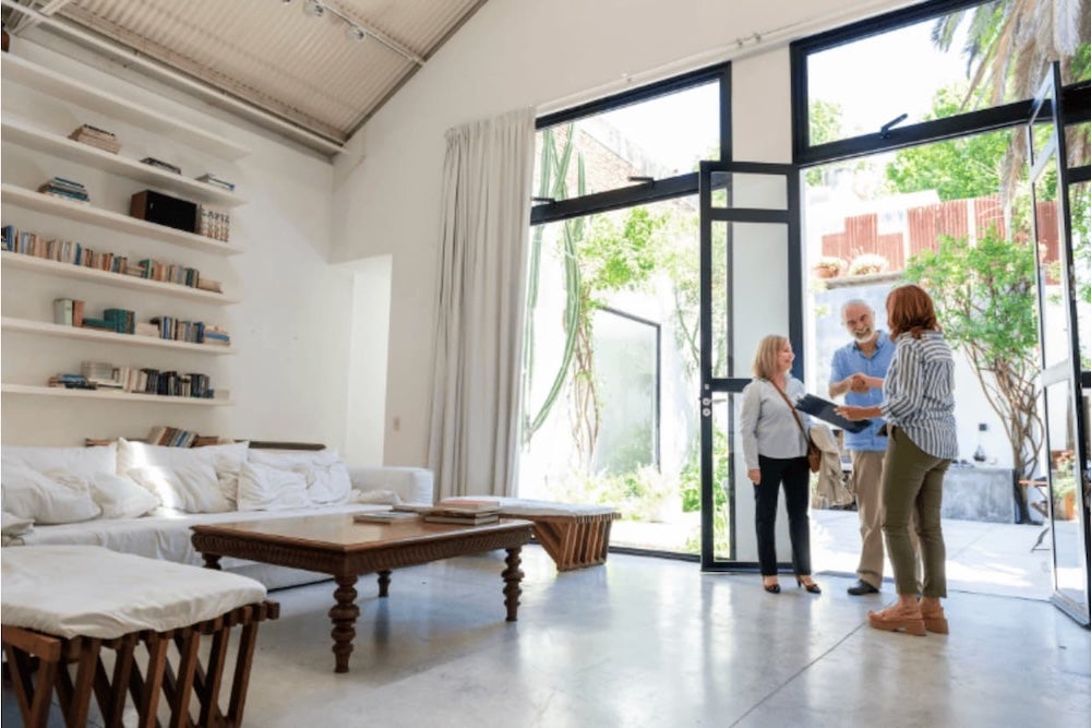 Three people looking round a house atrium