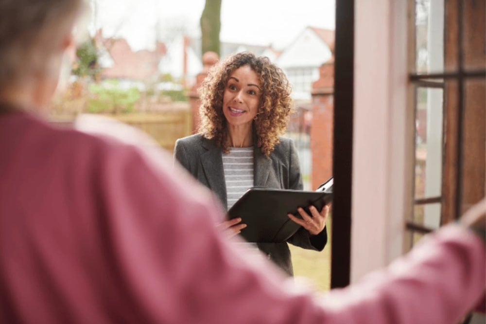 An agent talking to somebody by their front door